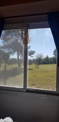a window with a view of a field of grass at Tiny Samay Punto Claro in Villa Ciudad Parque