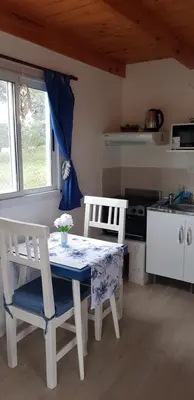a kitchen with a table and two chairs and a stove at Tiny Samay Punto Claro in Villa Ciudad Parque