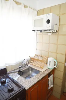 a kitchen counter with a sink and a microwave at Departamento lindo y cálido in Cordoba