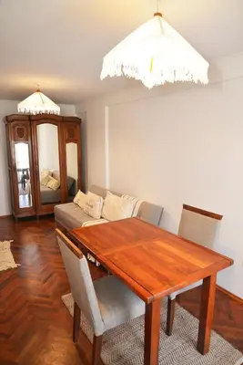 a dining room with a wooden table and a couch at Departamento lindo y cálido in Cordoba