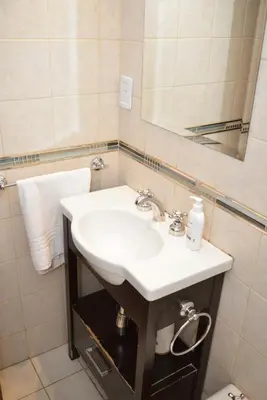 a bathroom with a white sink and a mirror at Departamento lindo y cálido in Cordoba