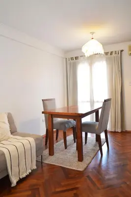 a dining room with a table and chairs and a couch at Departamento lindo y cálido in Cordoba