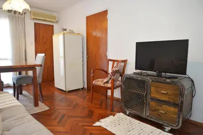 a living room with a flat screen tv and a table at Departamento lindo y cálido in Cordoba