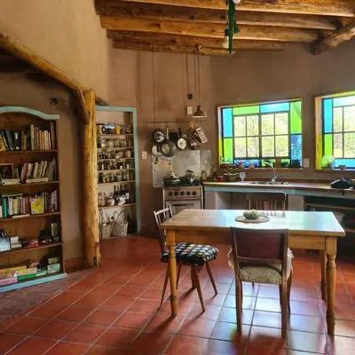 a kitchen with a wooden table and chairs at Casa de Monte in Cerro de Oro