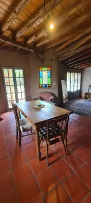 a dining room with a wooden table and a chair at Casa de Monte in Cerro de Oro