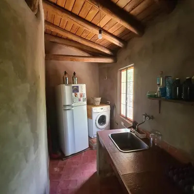 a kitchen with a refrigerator and a washing machine at Casa de Monte in Cerro de Oro