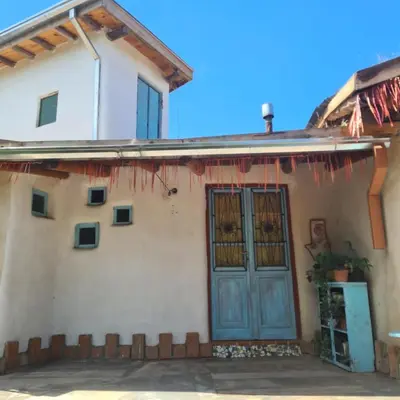 a house with a blue door on the side of it at Casa de Monte in Cerro de Oro