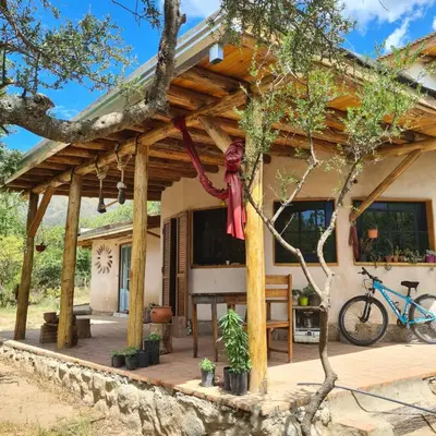 a house with a wooden porch with a tree at Casa de Monte in Cerro de Oro