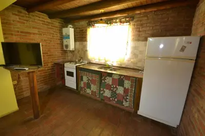 a kitchen with a white refrigerator and a window at El Viejo Molino Casas de Campo in Nono