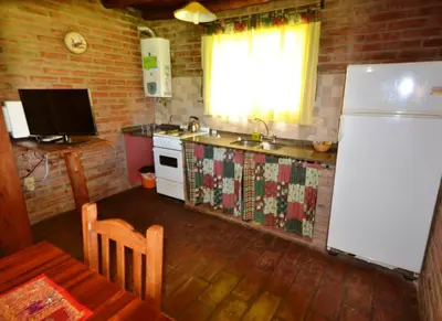 a kitchen with a white refrigerator and a table with a table sidx sidx at El Viejo Molino Casas de Campo in Nono