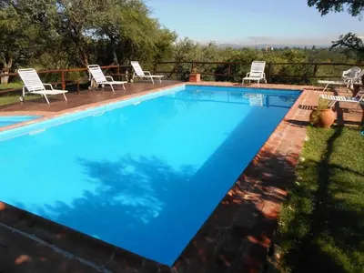a large blue swimming pool with chairs around it at El Viejo Molino Casas de Campo in Nono