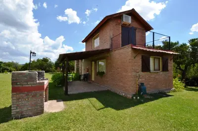 a small brick house on a grassy field at El Viejo Molino Casas de Campo in Nono