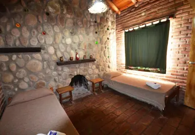 a room with a bed and a fireplace with a window at El Viejo Molino Casas de Campo in Nono