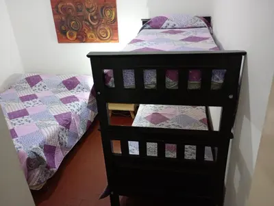 a black crib with a quilt on it next to a bed at El Dpto de Gabicito II in Cordoba