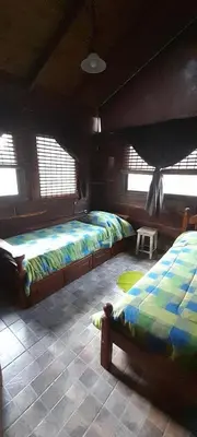 a bedroom with two beds in a room with windows at Cabaña Waicol EXCLUSIVA in Potrero de Garay