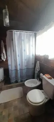 a bathroom with a toilet and a shower curtain at Cabaña Waicol EXCLUSIVA in Potrero de Garay