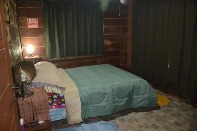 a bedroom with a bed with a green comforter at Cabaña Waicol EXCLUSIVA in Potrero de Garay