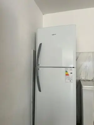 a white refrigerator freezer in a kitchen next to a wall at Depto1 in Río Cuarto