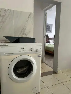 a washing machine in a room with a bedroom at Depto1 in Río Cuarto