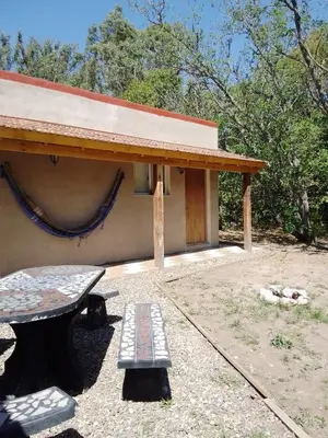 a picnic table and a bench in front of a building at Dormis Clave de Sol -dos in Villa Ciudad Parque