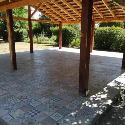 a patio with a tile floor and a wooden roof at Dormis Clave de Sol -dos in Villa Ciudad Parque