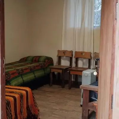 a bedroom with two beds and two chairs and a window at Dormis Clave de Sol -dos in Villa Ciudad Parque