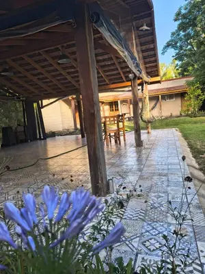 a patio with a table and blue flowers at Dormis Clave de Sol -dos in Villa Ciudad Parque