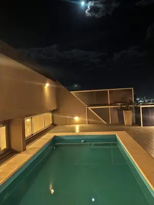 a swimming pool on the roof of a house at night at IBBA - Departamento en Nueva Cordoba con pileta in Cordoba