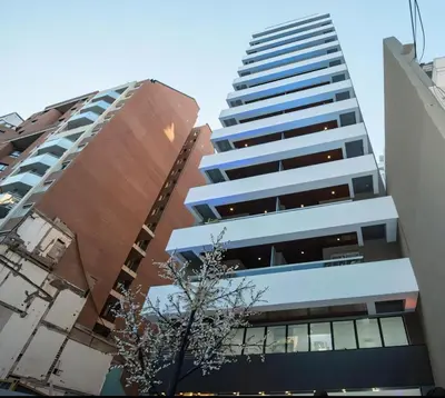 a tall building in the middle of two other buildings at IBBA - Departamento en Nueva Cordoba con pileta in Cordoba