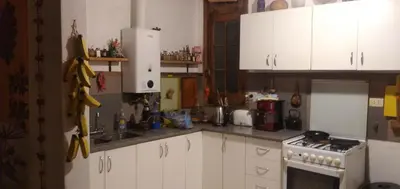 a kitchen with white cabinets and a white refrigerator at La bien querida in Cordoba
