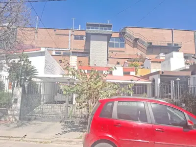 a red car parked in front of a fence at La bien querida in Cordoba