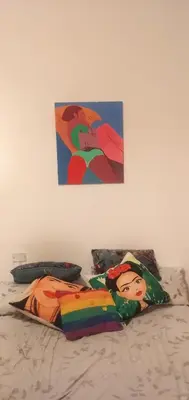 a bed with two pillows and a painting on the wall at La bien querida in Cordoba