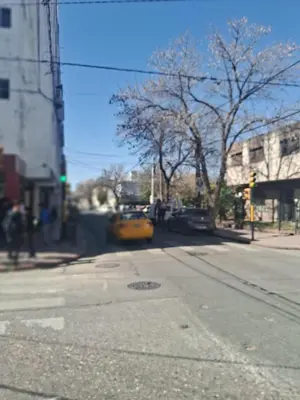 a yellow taxi cab driving down a city street at La bien querida in Cordoba