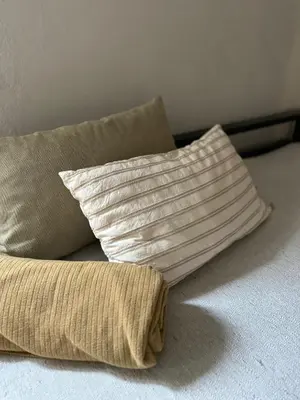 two pillows are sitting on a bed with a pillow at Casa López en el centro de Santa Rosa de Calamuchita in Santa Rosa de Calamuchita