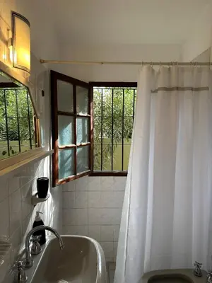 a bathroom with a tub and a sink and a window at Casa López en el centro de Santa Rosa de Calamuchita in Santa Rosa de Calamuchita