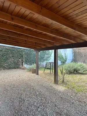 a wooden pergola with a picnic table in a field at Casa López en el centro de Santa Rosa de Calamuchita in Santa Rosa de Calamuchita