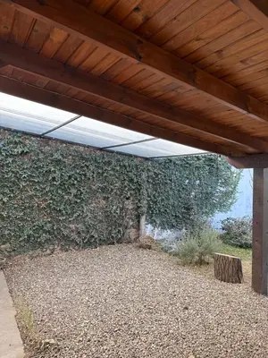 a large brick wall with a wooden ceiling at Casa López en el centro de Santa Rosa de Calamuchita in Santa Rosa de Calamuchita
