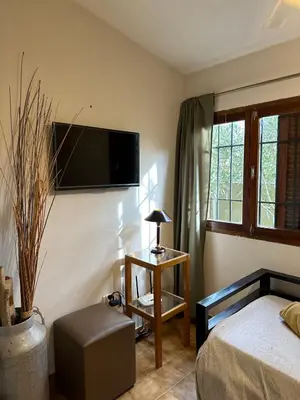 a bedroom with a bed and a television on the wall at Casa López en el centro de Santa Rosa de Calamuchita in Santa Rosa de Calamuchita