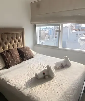 two stuffed animals on top of a bed with a window at Apartament vista Buen pastor in Cordoba