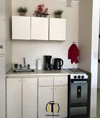 a kitchen with white cabinets and a stove at Apartament vista Buen pastor in Cordoba
