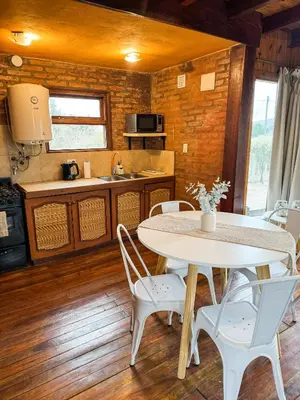 a kitchen with a table and chairs in a room at Casa Mona in Potrero de Garay
