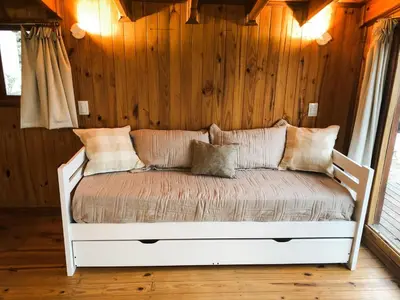 a white bed in a room with wooden walls at Casa Mona in Potrero de Garay
