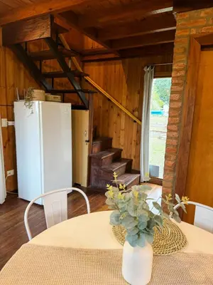 a dining room with a table and a refrigerator at Casa Mona in Potrero de Garay