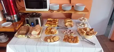 a table with many different types of pastries and bread at Las Lechuzas Complejo in Santa Rosa de Calamuchita