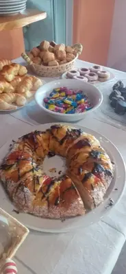 a table topped with a doughnut with sprinkles and other pastries at Las Lechuzas Complejo in Santa Rosa de Calamuchita