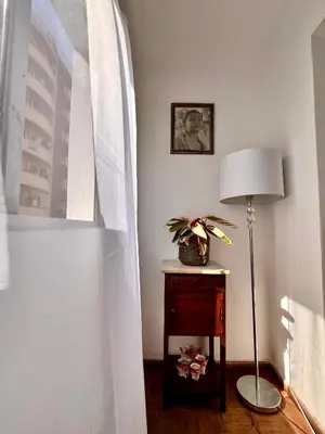 a room with a table with a lamp and a window at Departamentos Refugio del Rio in Cordoba