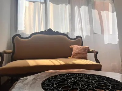a chair sitting in front of a window with curtains at Departamentos Refugio del Rio in Cordoba