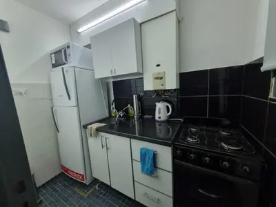 a small kitchen with a stove and a refrigerator at TREJO APART, A 40MTS DEL PATIO OLMOS, PLANTA BAJA in Cordoba