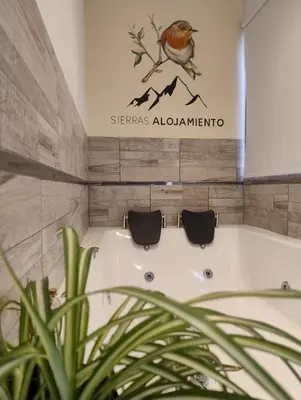 a bath tub with a bird on a sign in a bathroom at Apart Deluxe in Mina Clavero