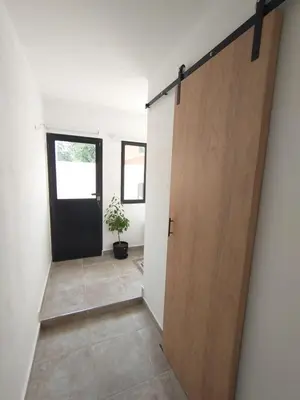 a hallway with a door and a potted plant at Apart Deluxe in Mina Clavero